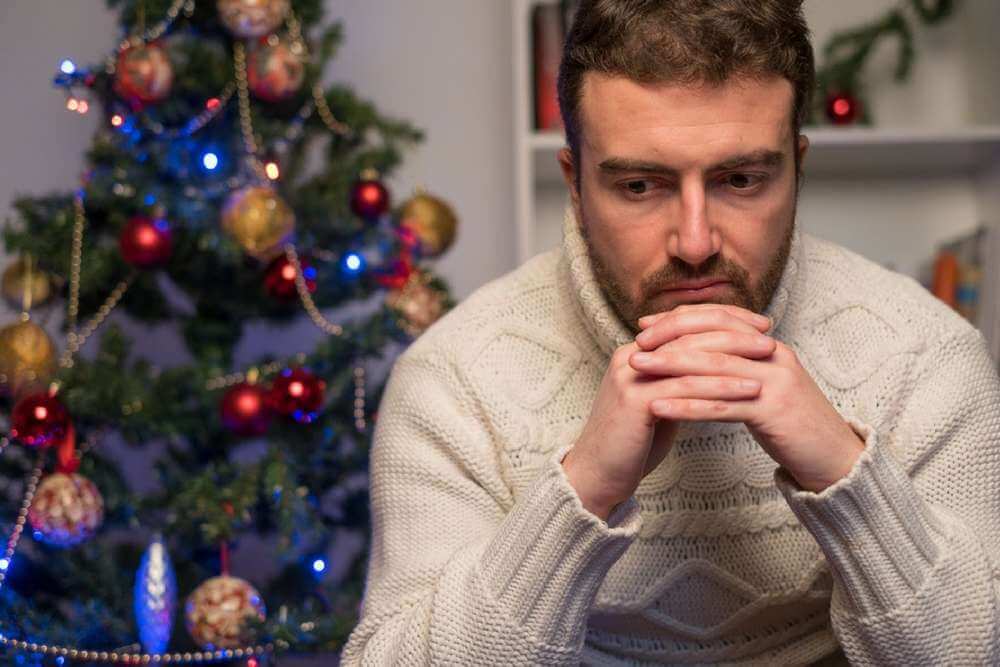 lighthousetreatment-how-to-manage-addiction-triggers-during-the-holidays-article-image-of-man-feeling-depressed-and-lonely-during-the-christmas-time-525688093