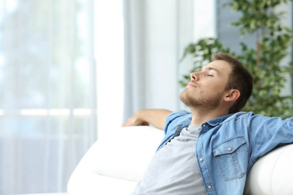 lighthousetreatment-how-mindfulness-affects-addiction-recovery-article-photo-of-portrait-of-a-casual-tired-man-resting-sitting-on-a-couch-at-home-446681404