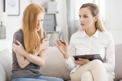 a teen female talking to a therapist on a couch