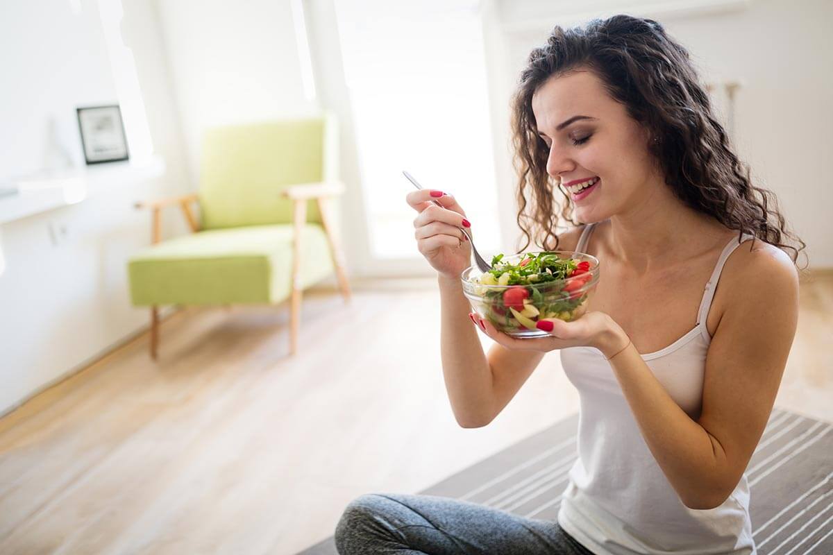 lighthousetreatment--the-tools-you-need-to-stay-sober-in-college-article-photo-beautiful-woman-eating-healthy-fresh-organic-salad-533084056