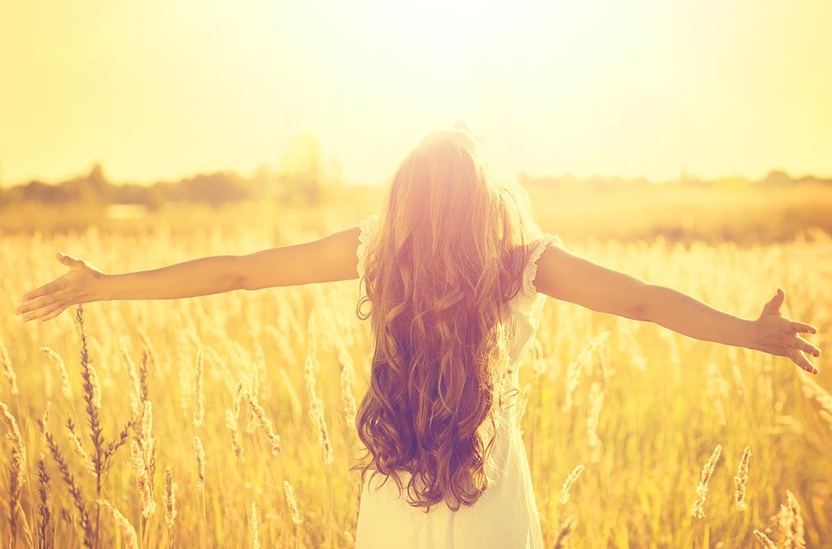 lighthousetreatment-what-is-a-spiritual-awakening-in-recovery-article-photo-autumn-girl-enjoying-nature-on-the-field-beauty-girl-outdoors-raising-hands-in-sunlight-rays