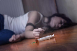 lighthousetreatment-what-is-heroin-cut-with-article-photo-close-up-on-the-floor-of-the-syringe-with-the-drug-in-the-background-a-young-drug-addict
