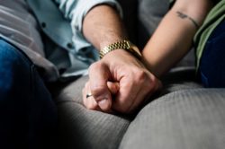 closeup of two hands of two people holding each other as an act of support 