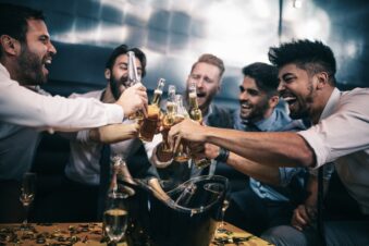 Group of male friends drinking beer in the club